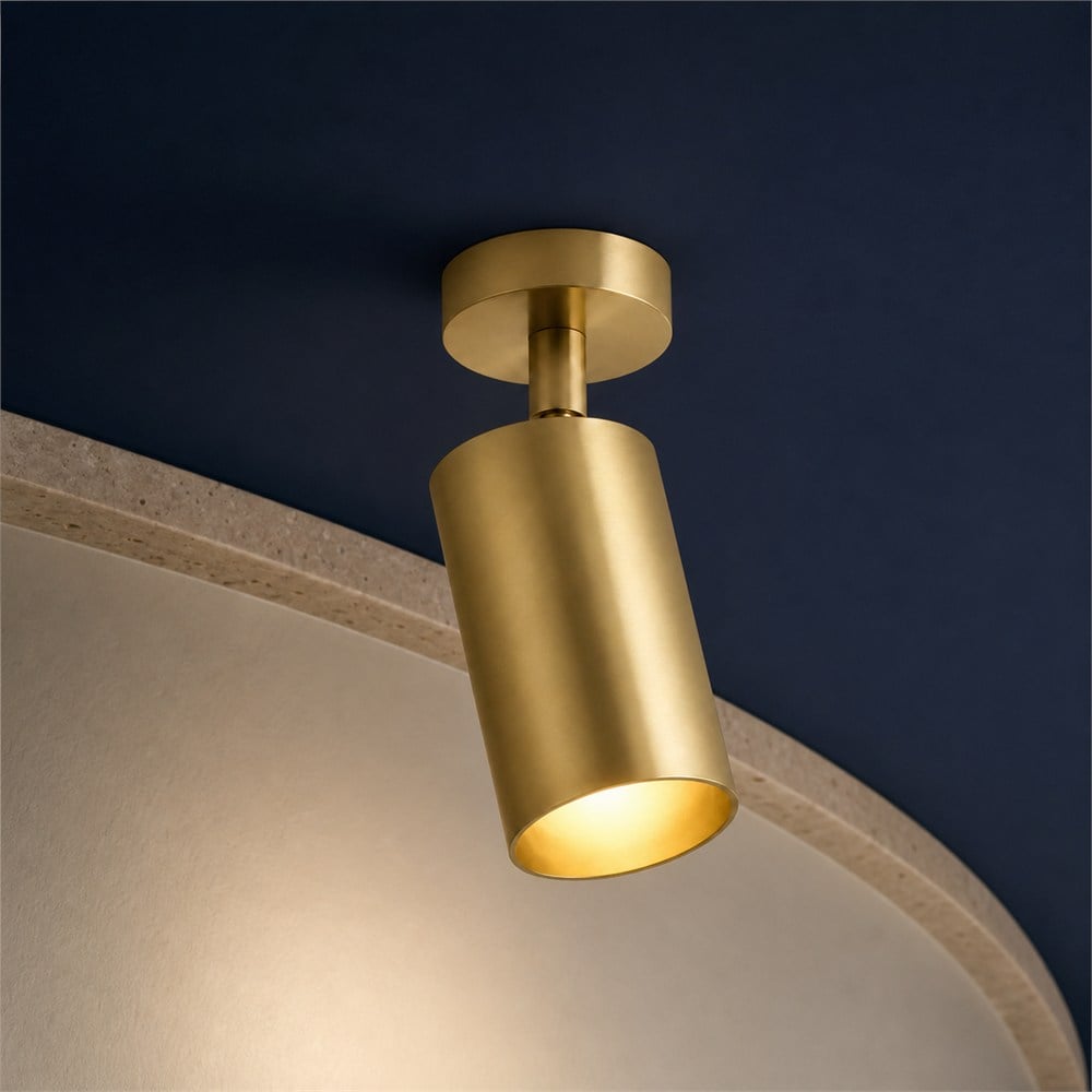 Brass cylinder ceiling spotlight in a walnut and navy setting