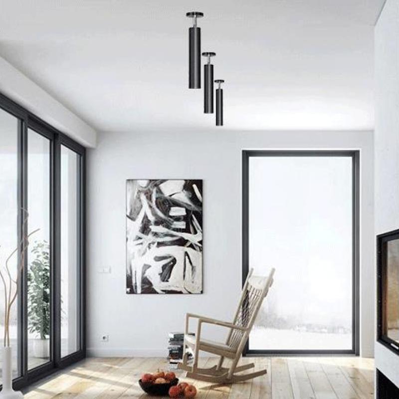 Three separate Black Freja tubular spotlights mounted vertically in a bright sitting room