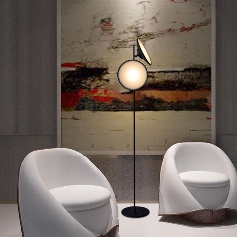 Illuminated black floor lamp between two white chairs