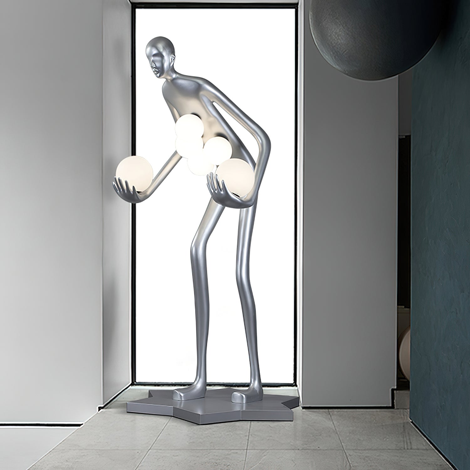 Silver figure and glowing white globes beside a tall window and dark circular wall ornament