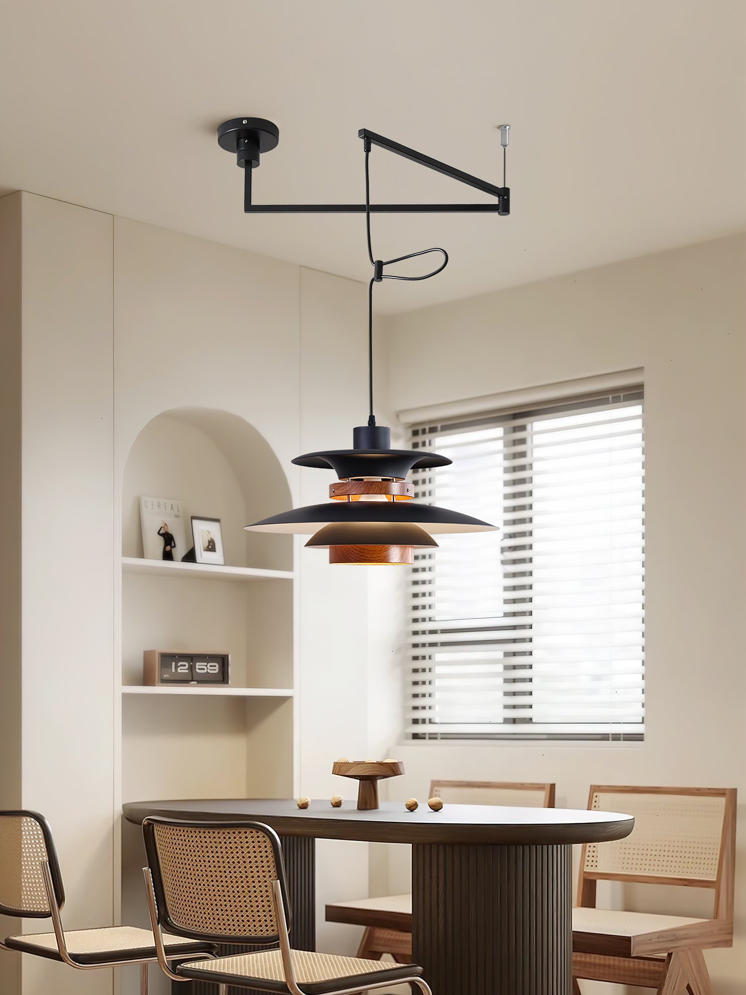 Black Mercero swing-arm pendant above a dining setting