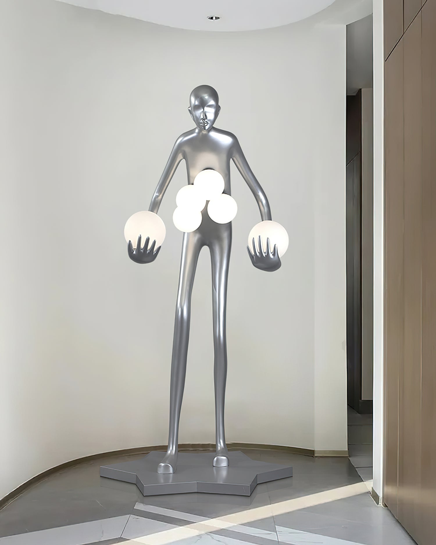 Wide frontal view of a silver figure with six glowing globes on a star-shaped base in a pale alcove