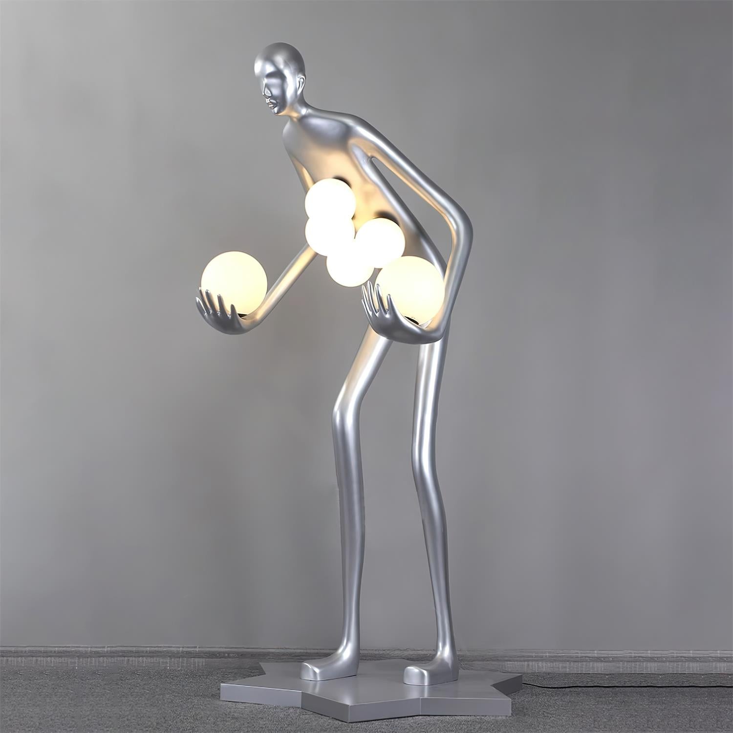 Front view of a silver figure with six glowing globes on gray carpet against a pale wall