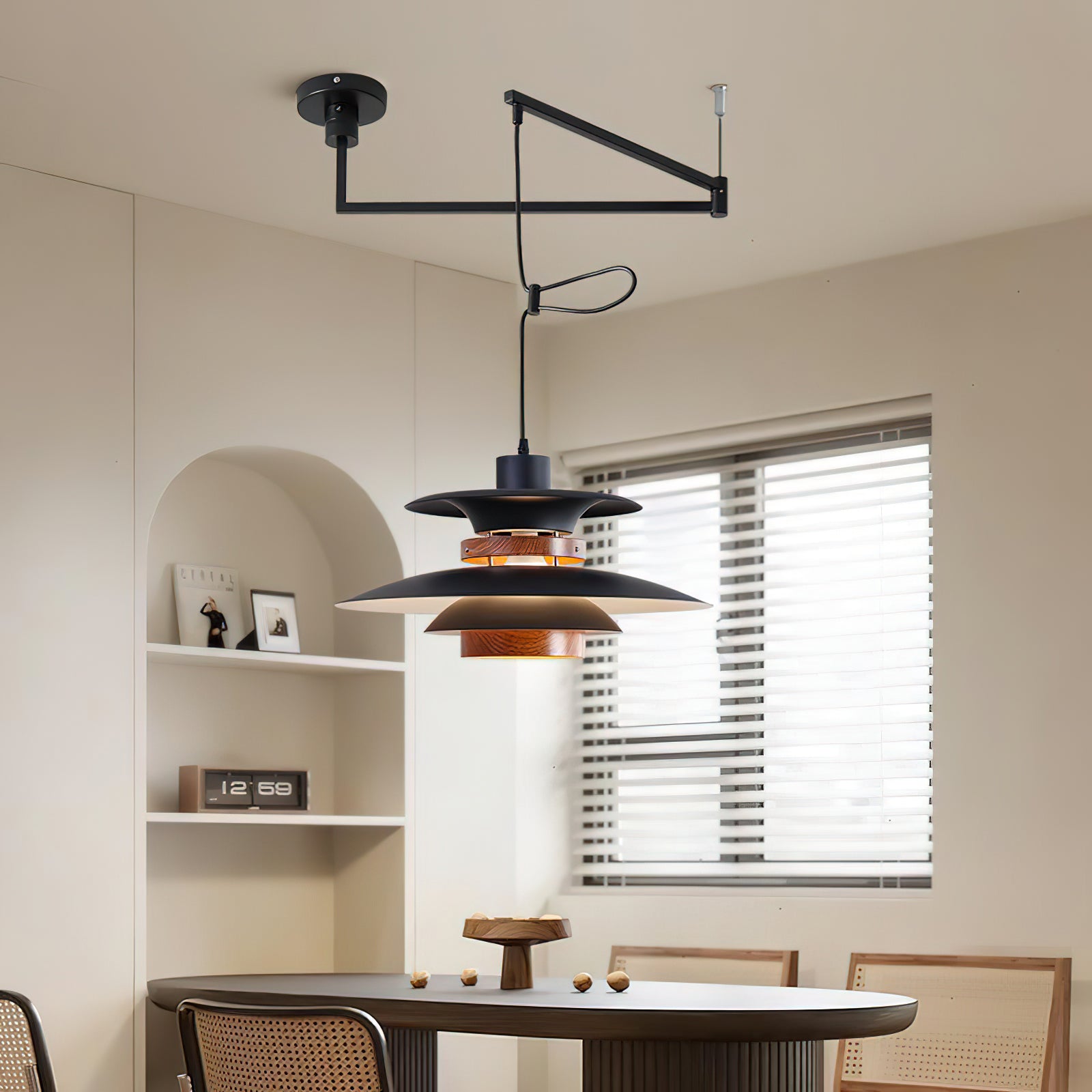 Black Mercero layered pendant above a long dark dining table beside an arched shelf