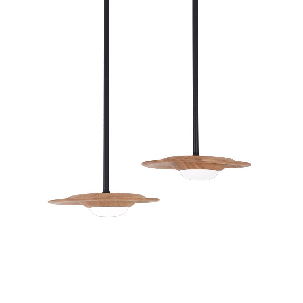 Two broad light wood-grain pendant shades at different drops on black rods, with white domed diffusers on pale grey