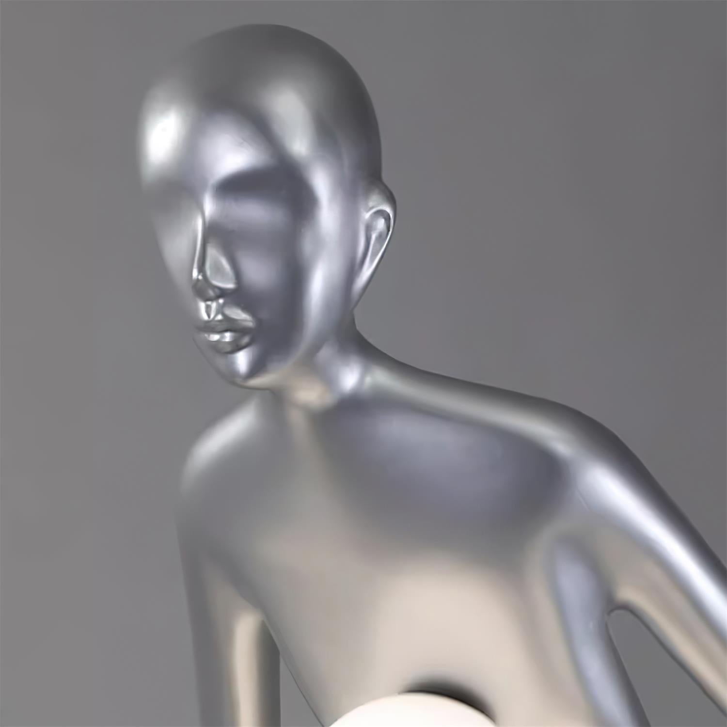 Close view of the silver figure’s face, neck and shoulder beside a white globe
