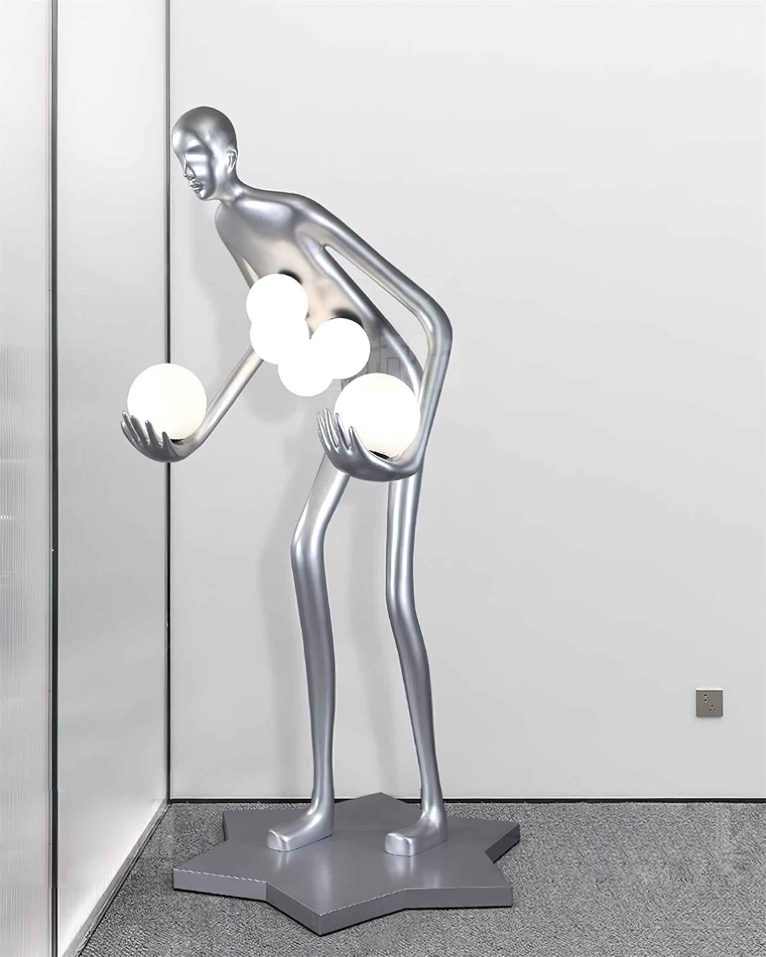 Silver figure and glowing white globes in a window corner, with a wall outlet at the right