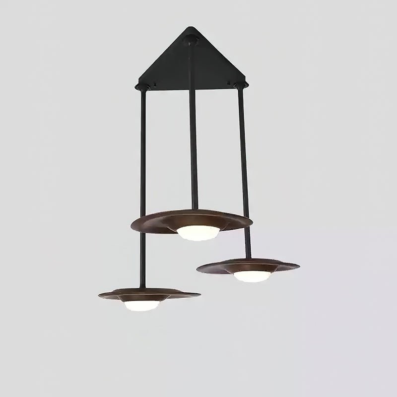 Three dark wood-tone pendant heads at staggered heights below a triangular black canopy, with white central diffusers