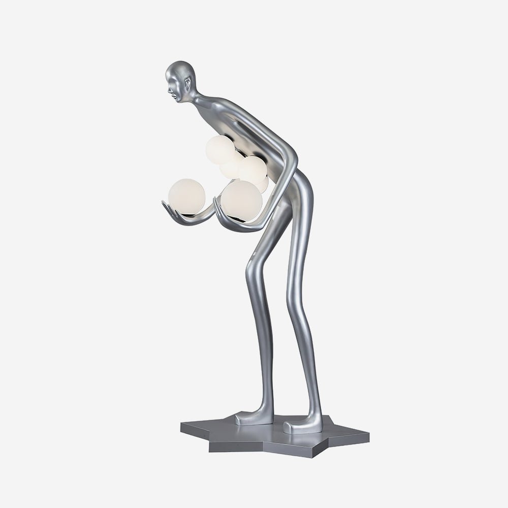 Silver human-figure floor lamp cradling white globes on a silver star-shaped base