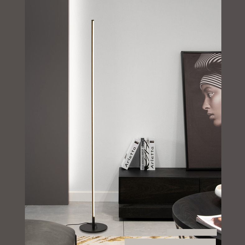 Edge straight floor light beside a dark sideboard and artwork