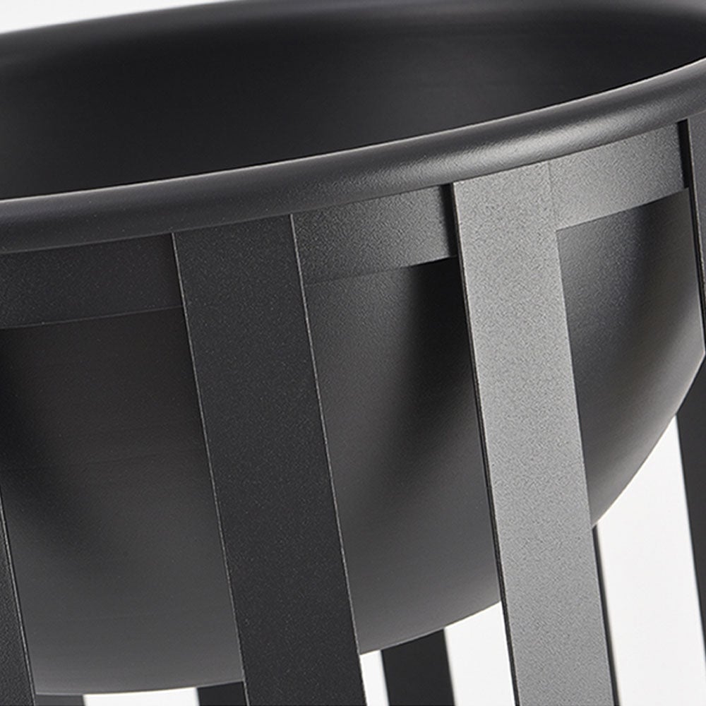 Close view of the black circular top tray, textured finish and vertical metal cage strips