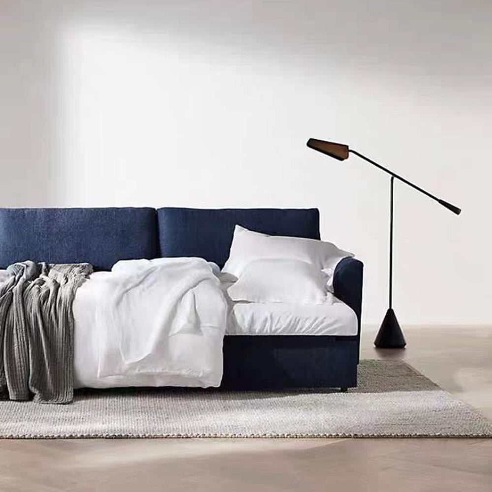 Marble-and-metal floor lamp at the side of a bed