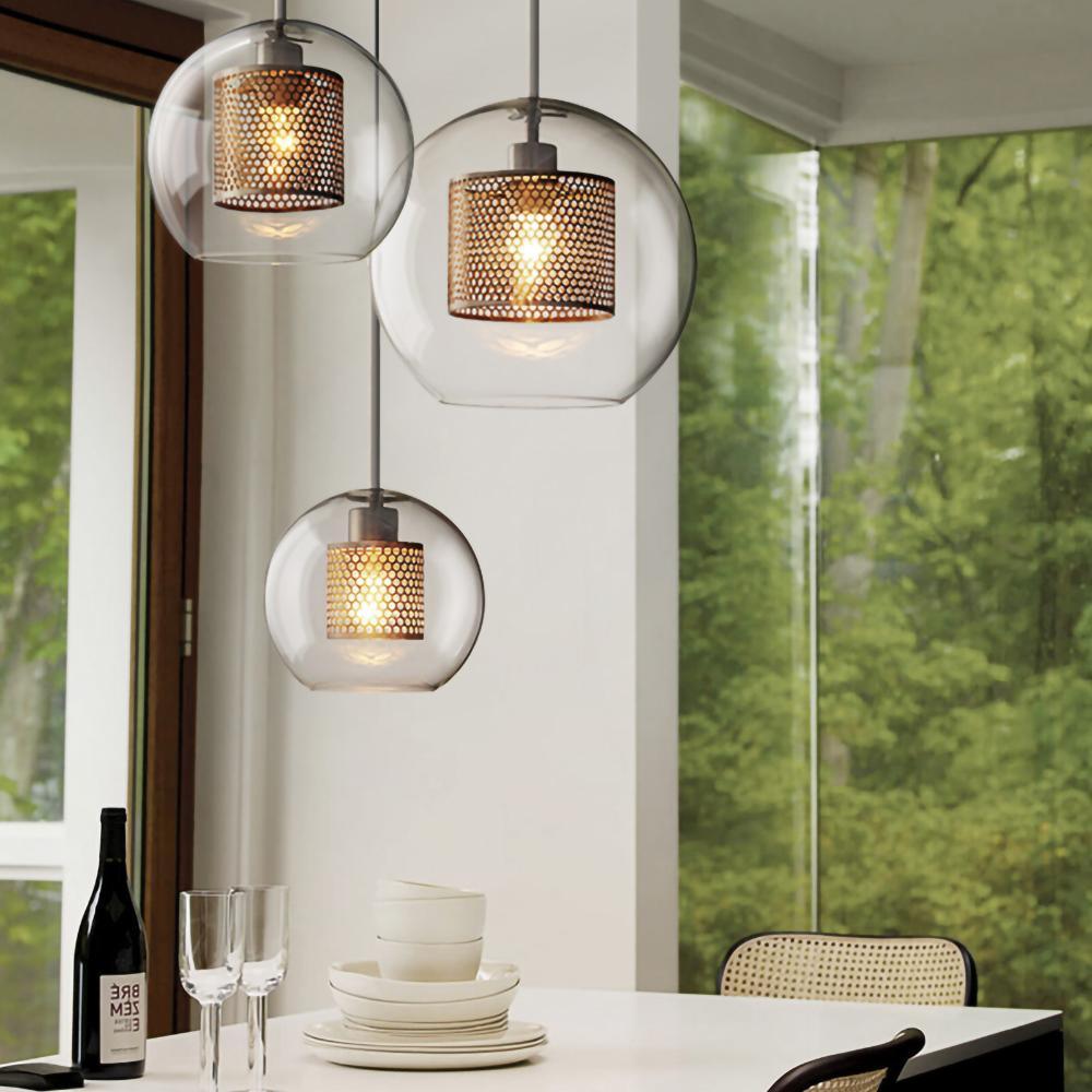 Three clear-glass pendants above a dining table