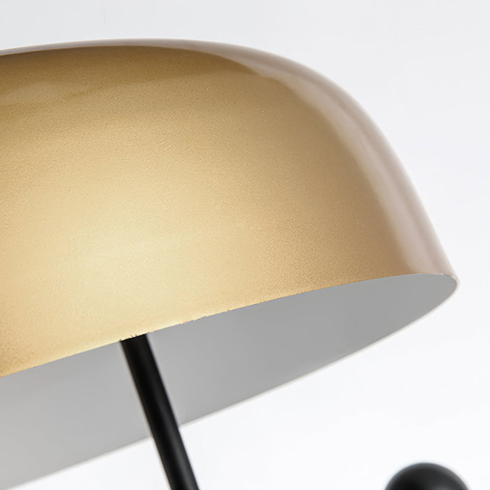 Close-up of rounded gold-tone shade edge, pale underside and black stem