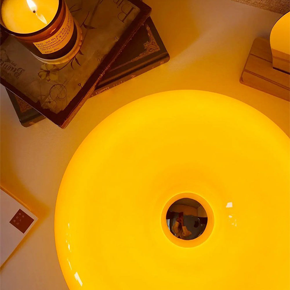 Close overhead view of the orange glowing ring and reflective centre beside a candle on stacked books