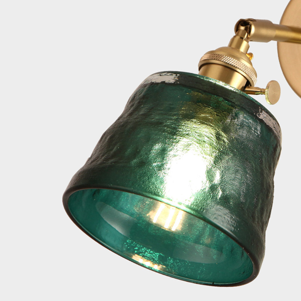 Close underside of lit green textured shade showing open rim, bulb silhouette, metal cap and joint
