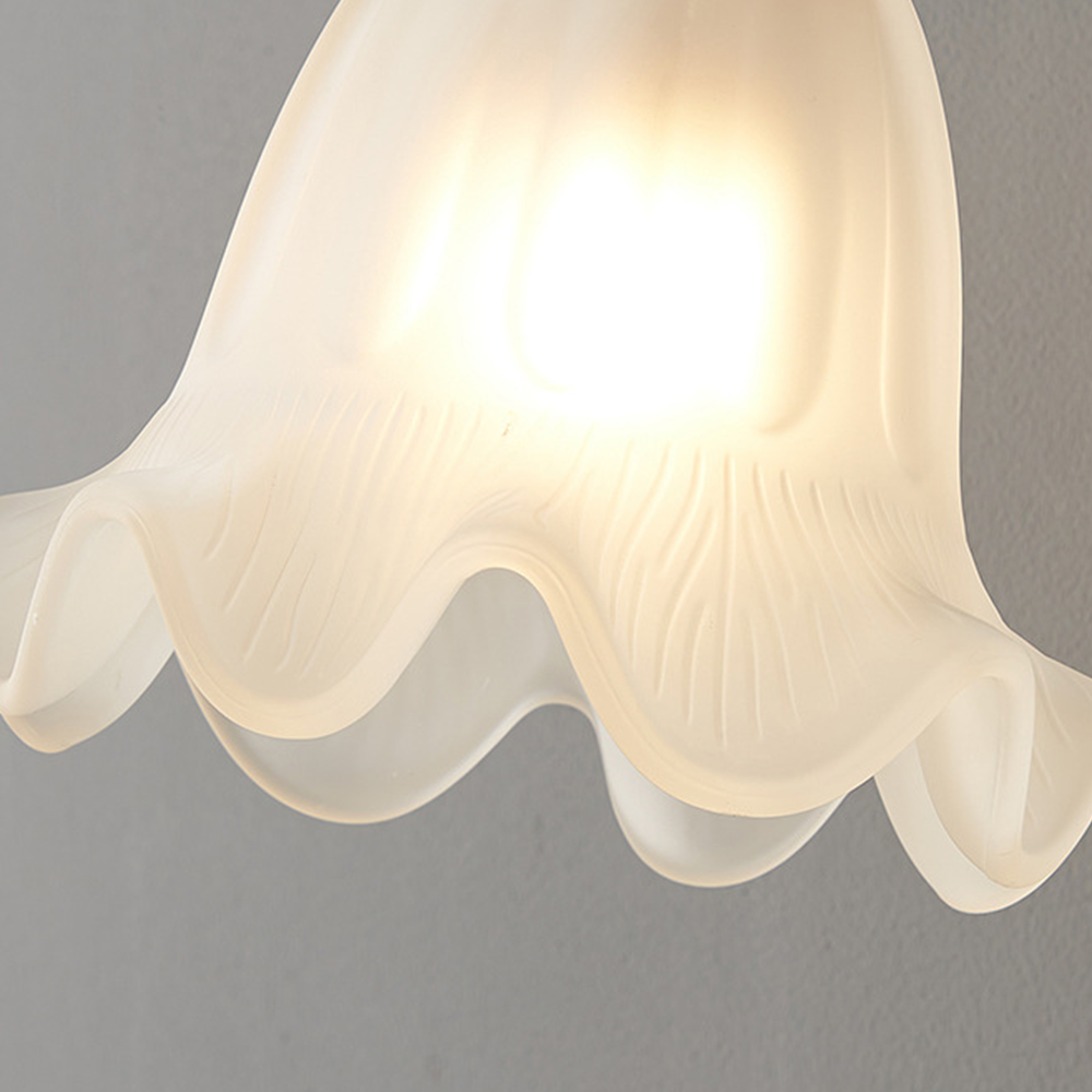 Close view of glowing white bell shade with fine ribs and layered wavy petal rim