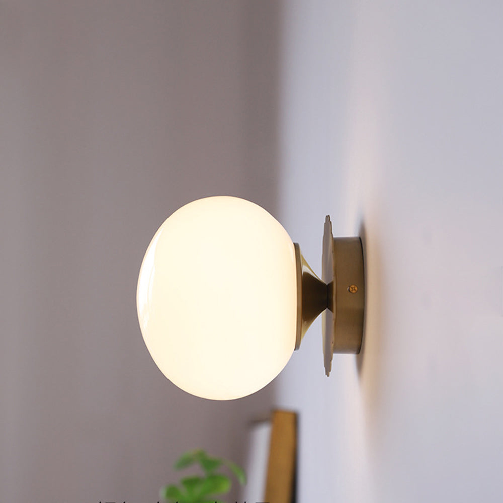 Side view of a glowing pale globe with gold-tone short connector and round rear plate
