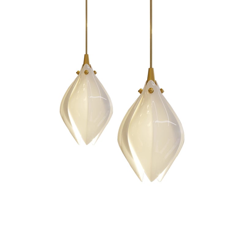 Two glowing white flower buds at different heights on gold-tone cords