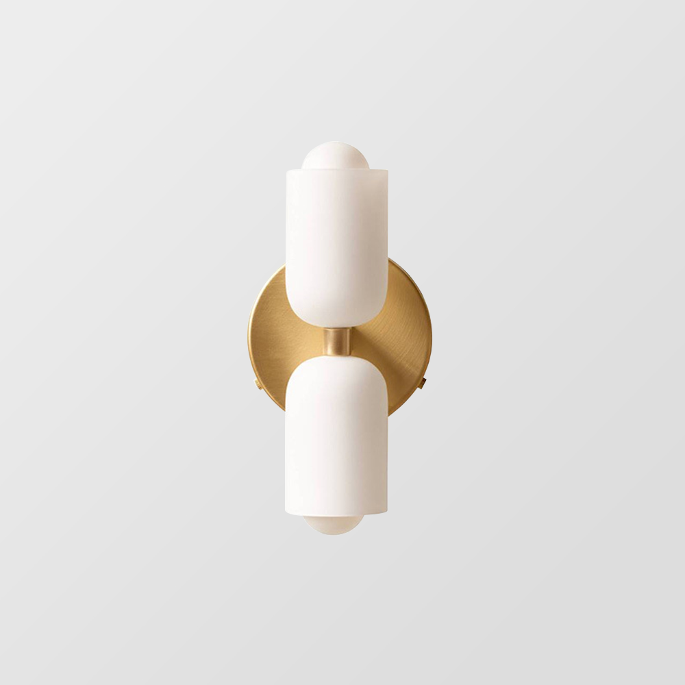 Isolated gold wall sconce with a round plate, short centre connector and opposed creamy-white cup shades