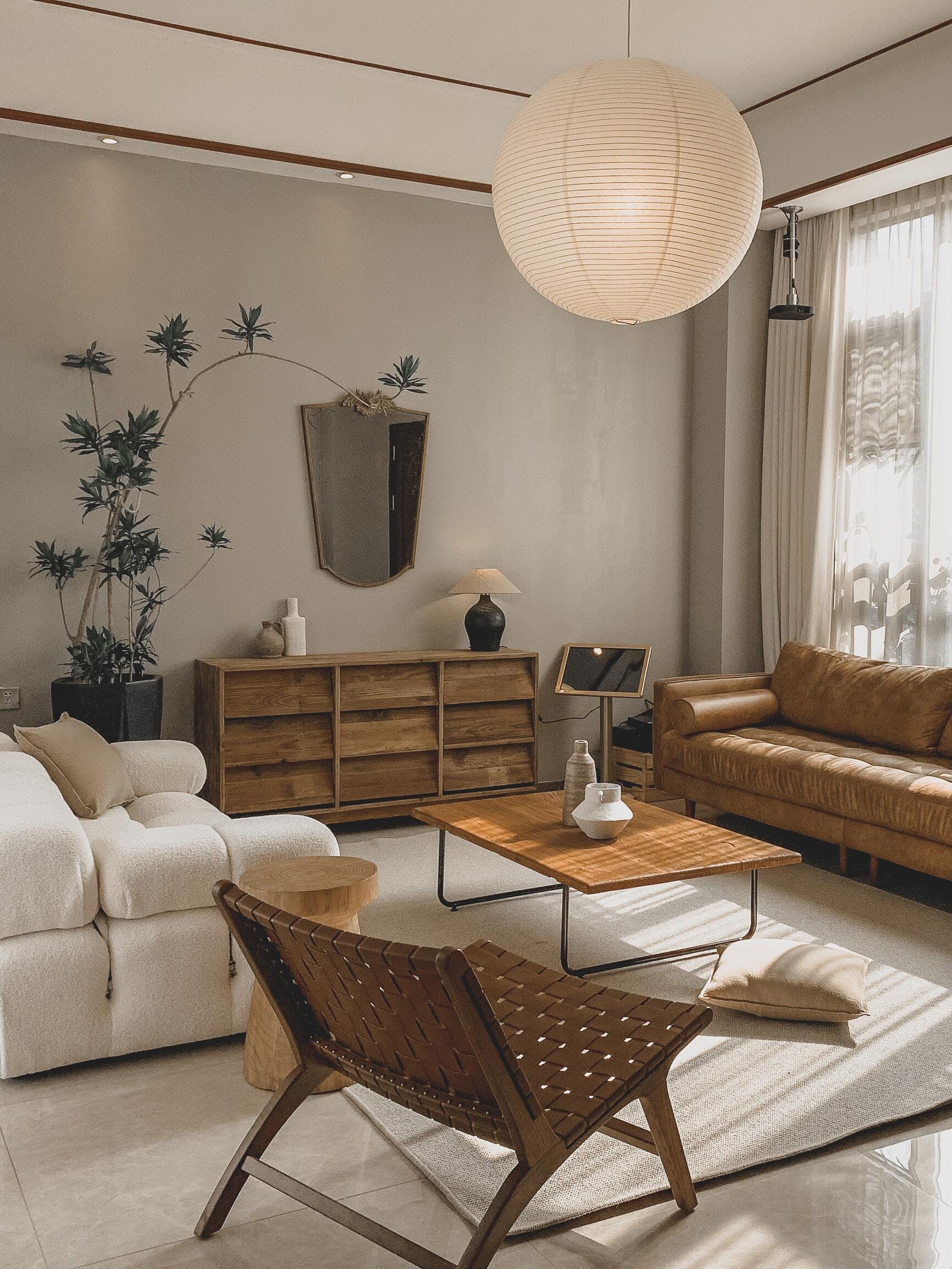 Wide lounge view with White globe, woven low chair, coffee vases and white and brown sofas