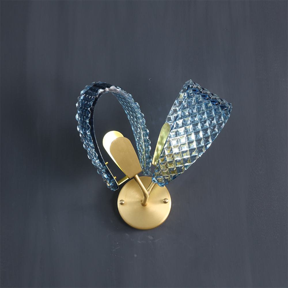 Oblique two-loop wall light with diamond-textured blue glass and gold-tone round plate and curved arms