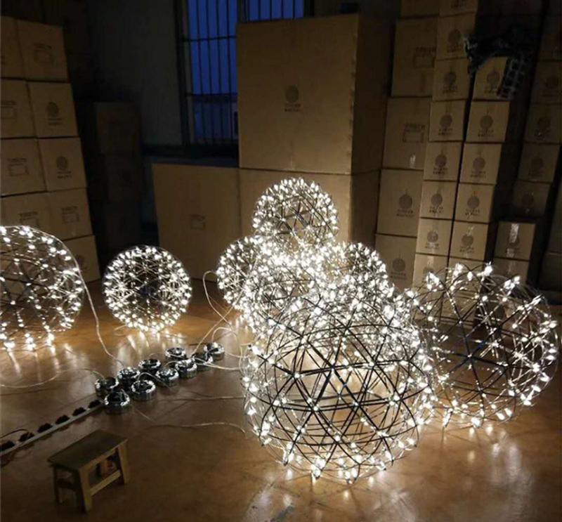 Several lit lattice globes resting on the floor beside boxes, power leads and canopies