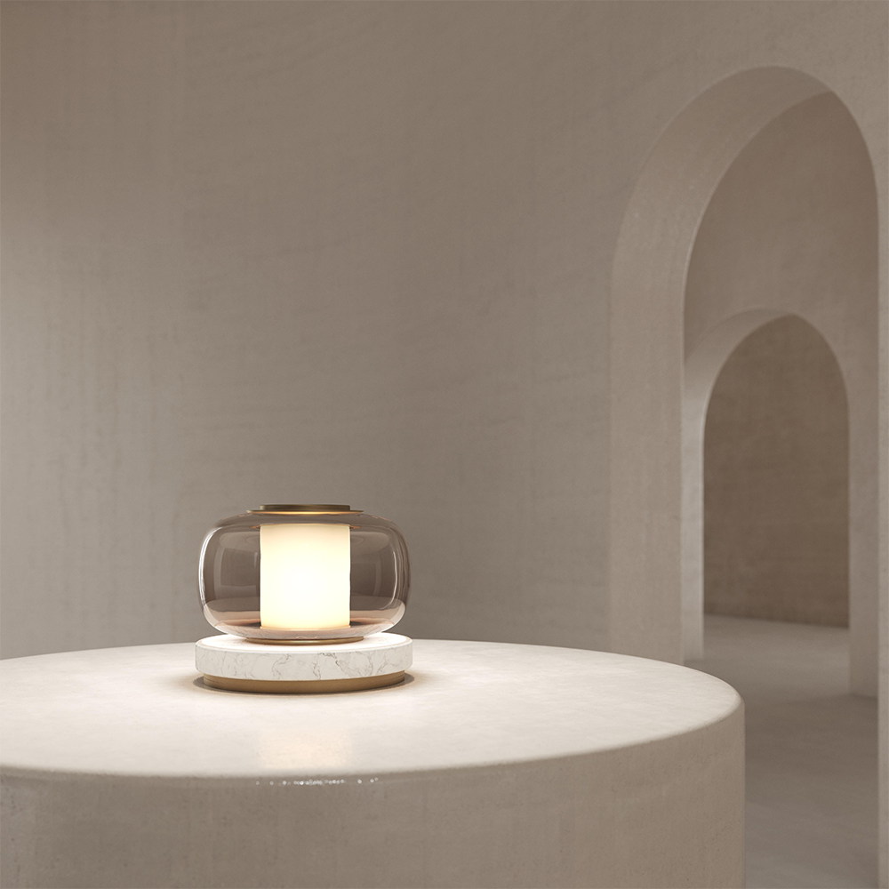 Light-brown glass lamp on a pale veined base glowing on a pale round pedestal table before beige arched recesses