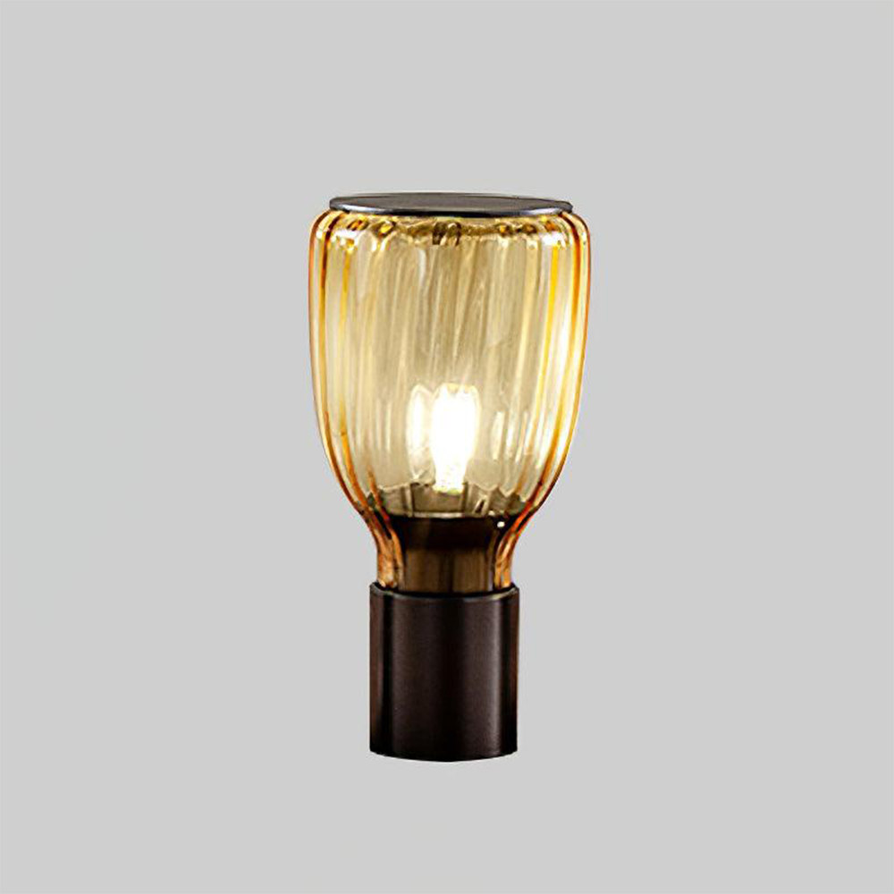 Brown bottle-shaped table lamp with transparent amber-brown ribbed glass and a black cylindrical base