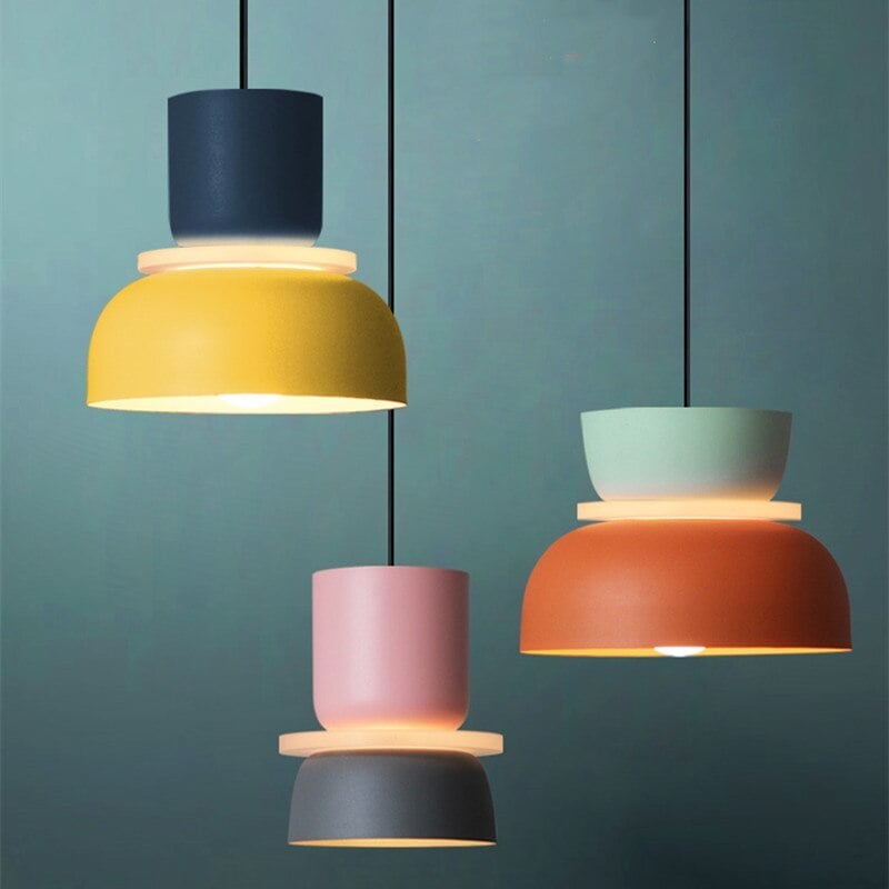 Three glowing two-tone pendants against a teal background, with pale discs between upper cups and lower shades