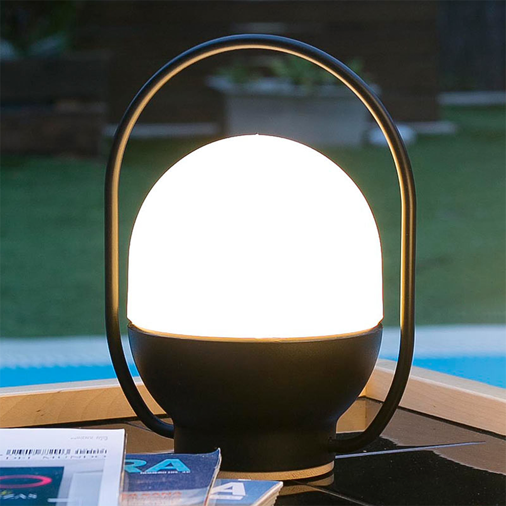 Illuminated rounded table lamp photographed beside a pool