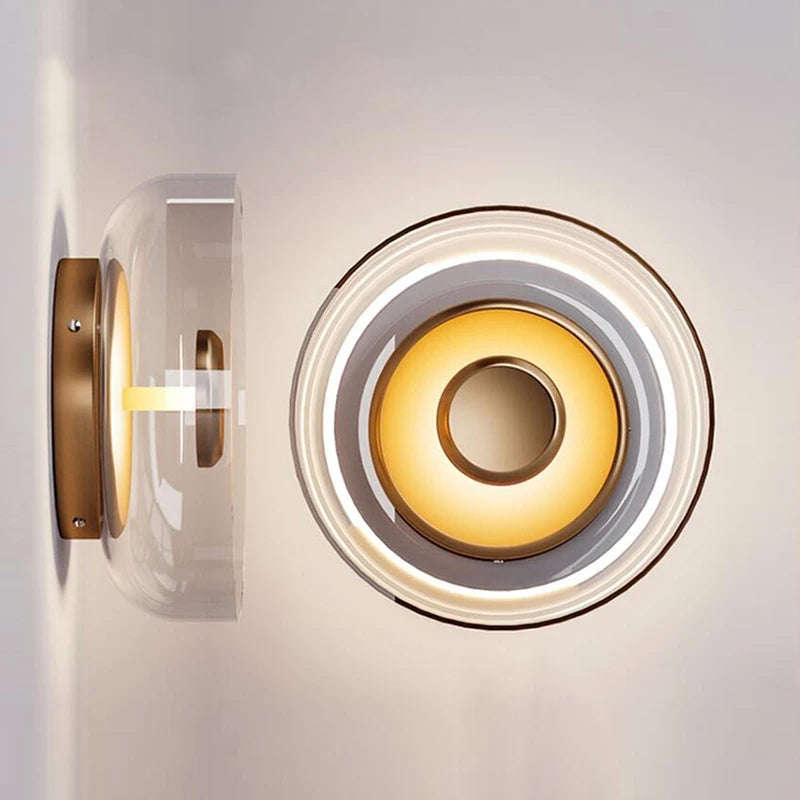 Front and side views of the transparent glass bowl wall light with gold-tone centre and rear plate
