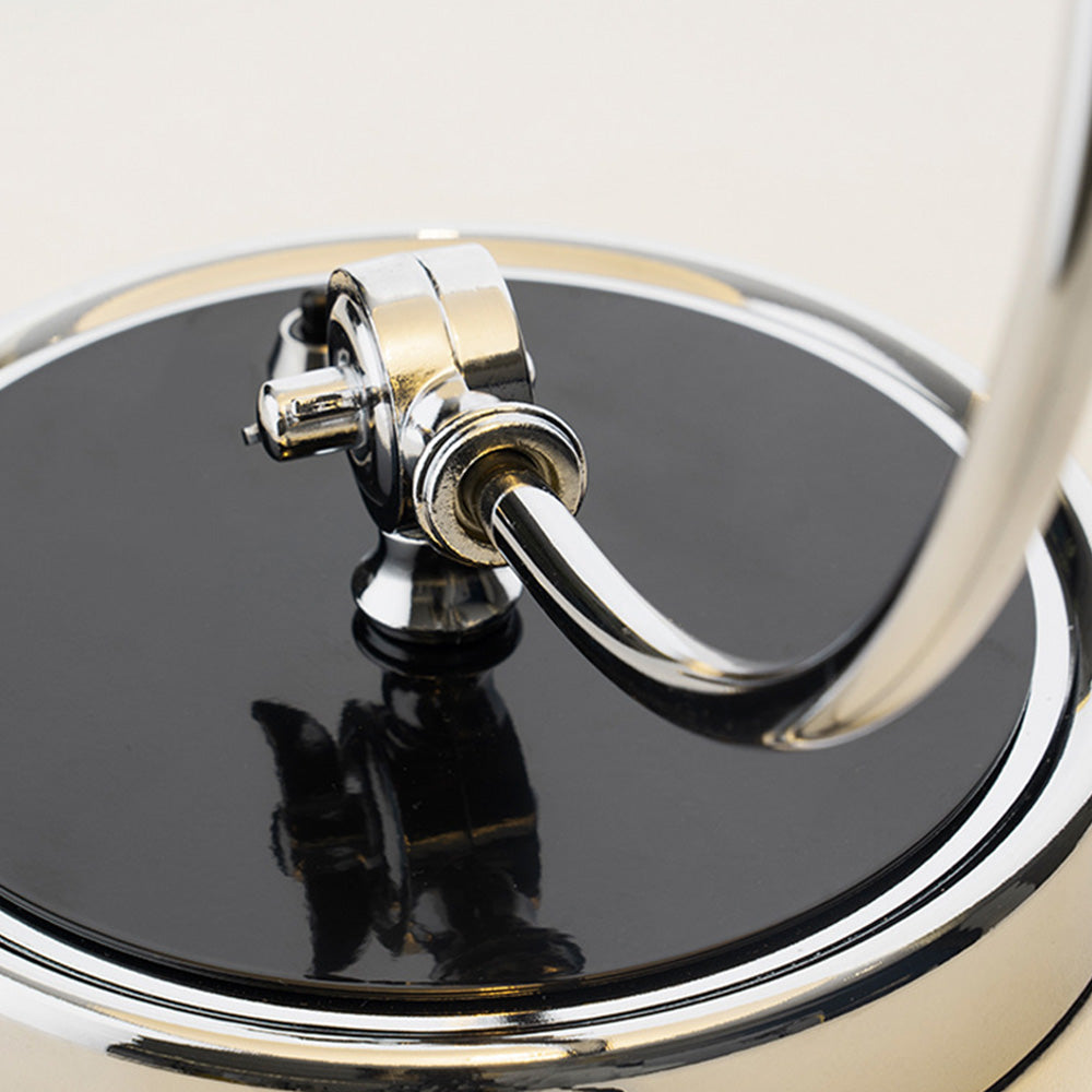 Close view of the circular stem joint, fastener and reflective rim on the black table-lamp base