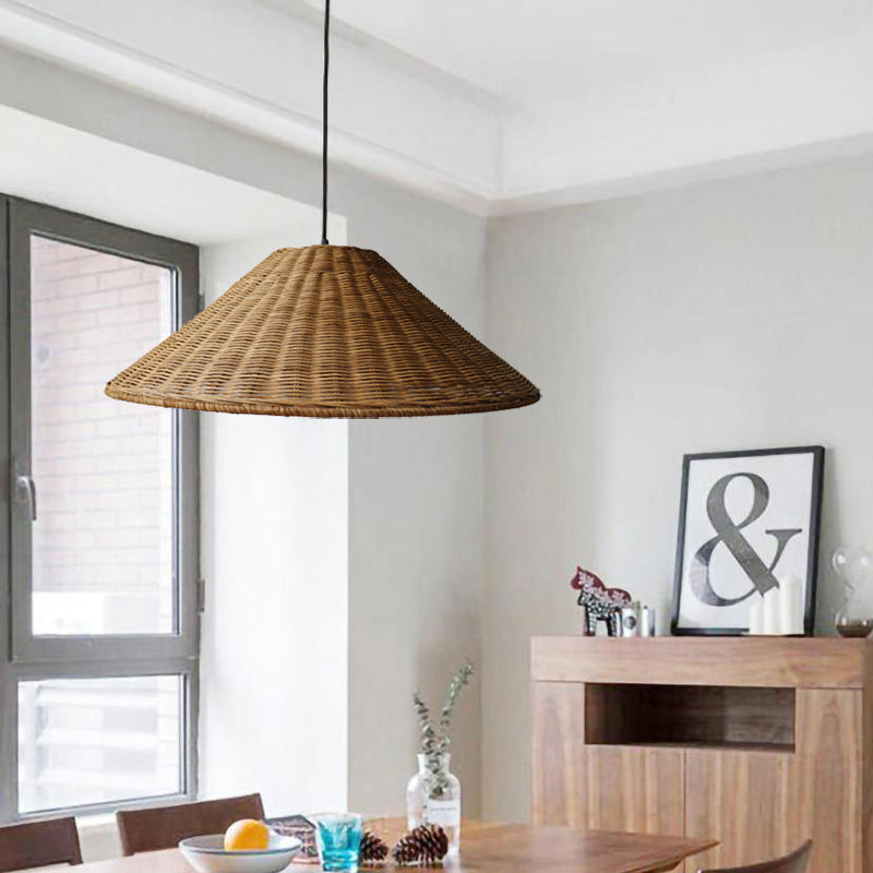 Brown cone pendant above a dining table beside a wood cabinet with framed ampersand artwork