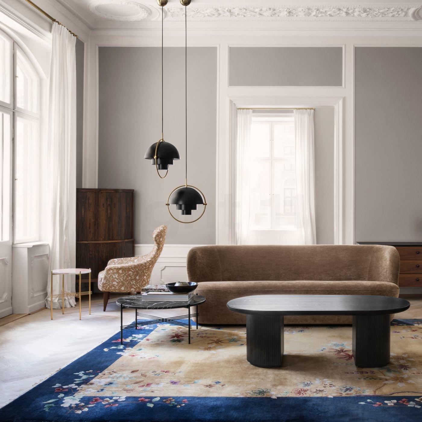 Two black ring pendants at different heights beside a sofa in a pale living room.