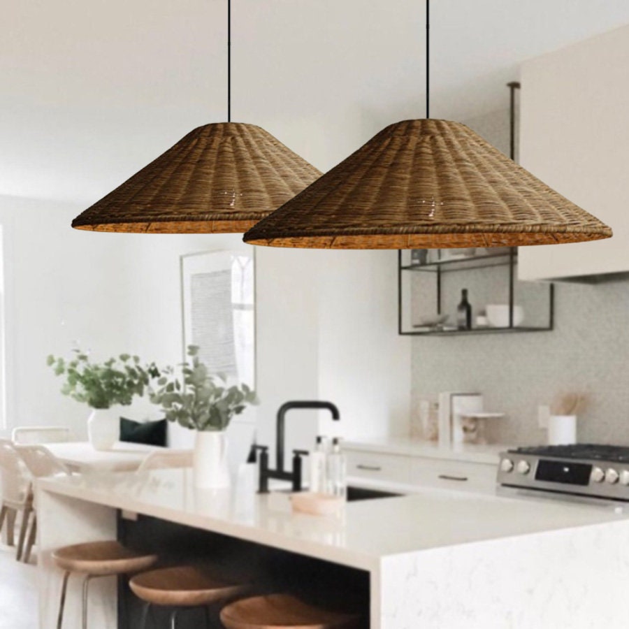 Two Brown woven cone shades above a white kitchen island with stools and a black faucet