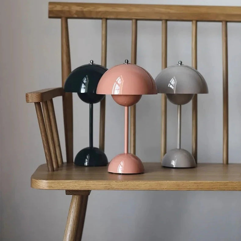 Green, pink and grey dome table lamps grouped on a wooden spindle-back bench