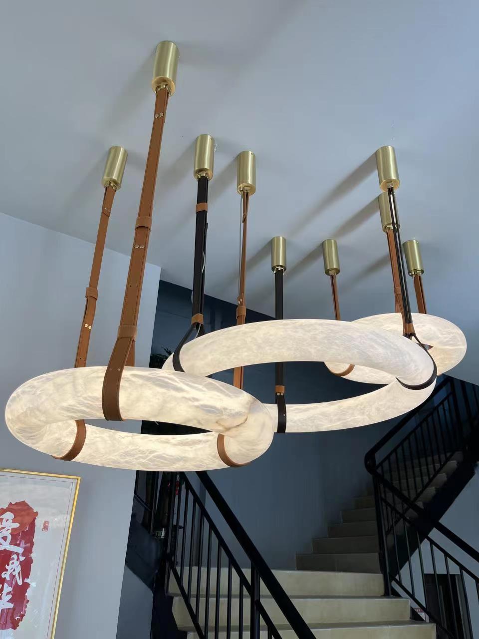Showroom display of ring pendants with separate cylindrical gold ceiling fittings.