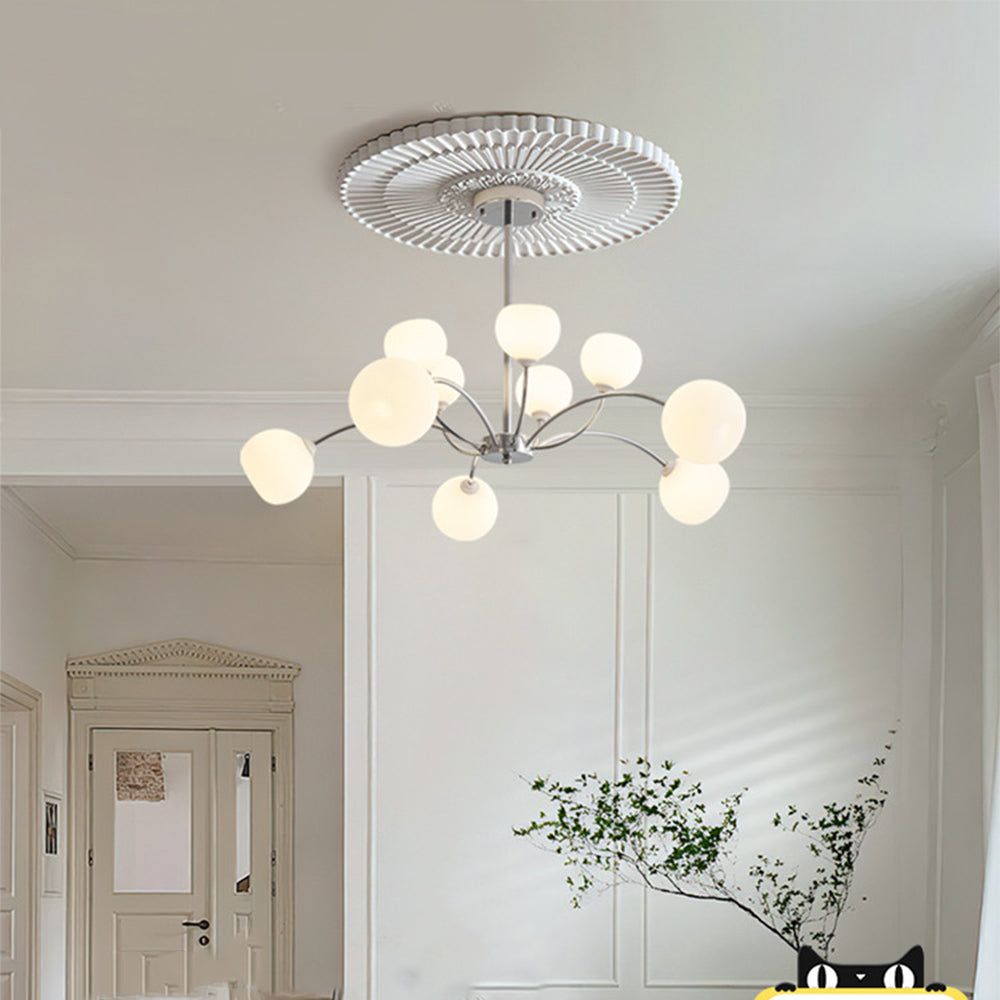 White-globe chrome chandelier against panelled walls, an ornate door and decorative branches