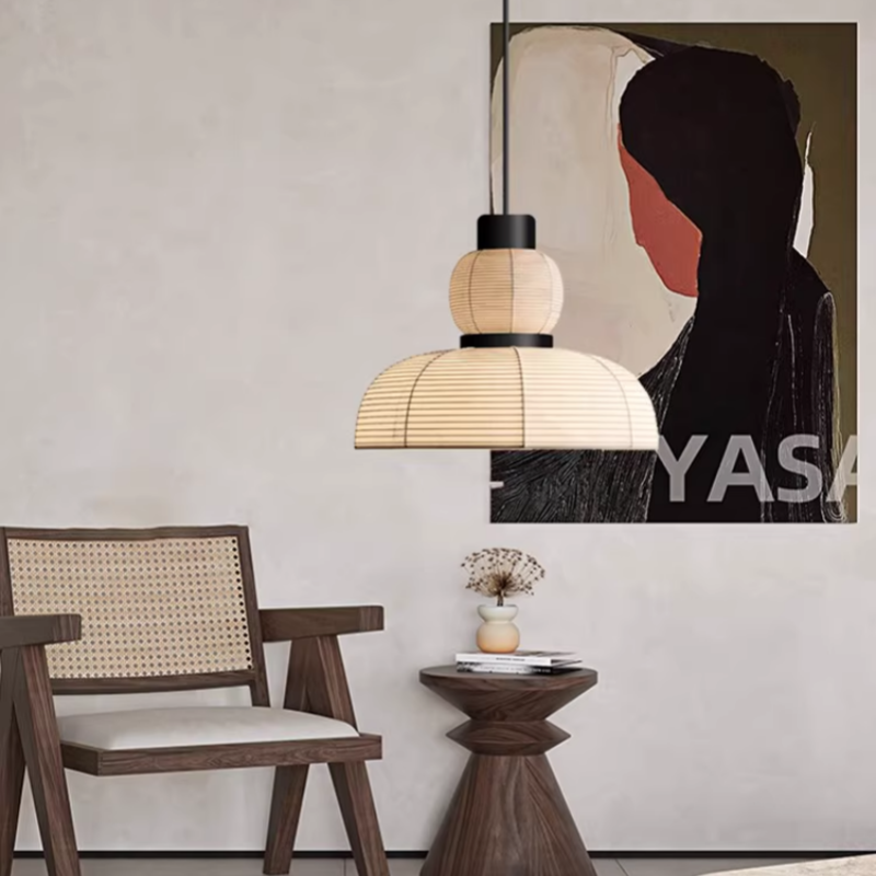 Upper-globe and lower-dome pendant beside a cane-back chair, small table and framed artwork