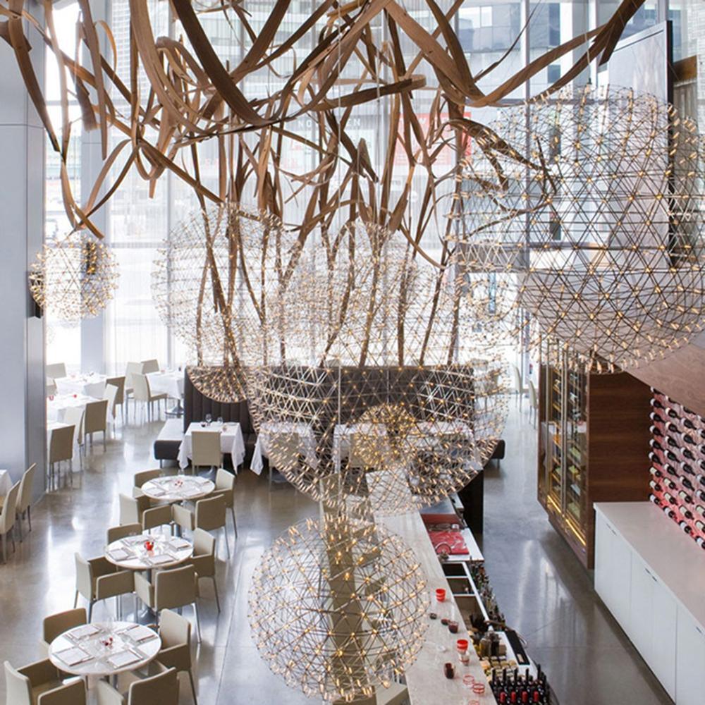 Glowing globe pendants above a bar with a wood sculpture and red-lit bottle shelves