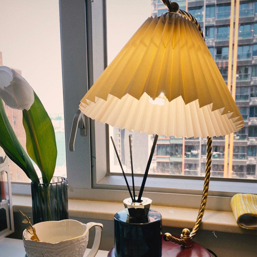 Close Beige Dotty pleated shade by a city window beside tulips, a cup and diffuser bottle