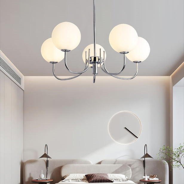Five illuminated white globes on chrome-tone arms in a bedroom with separate bedside lamps