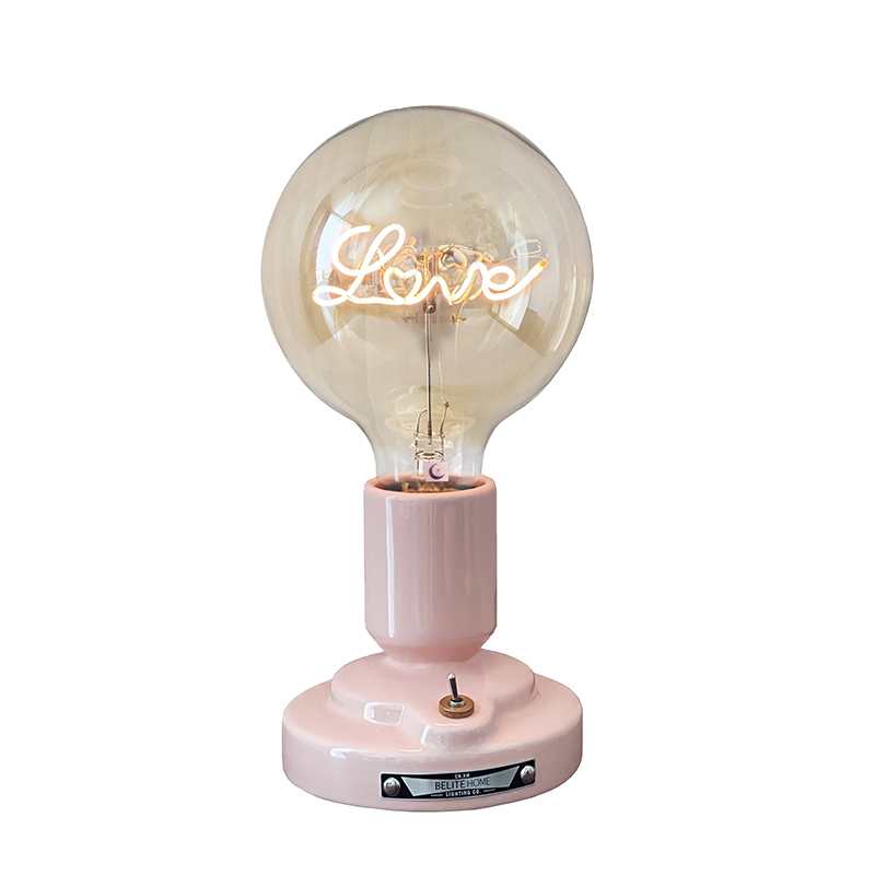 Isolated upright Love-lettering globe lamp with a glossy pink cylindrical holder, rounded stepped foot and small lever