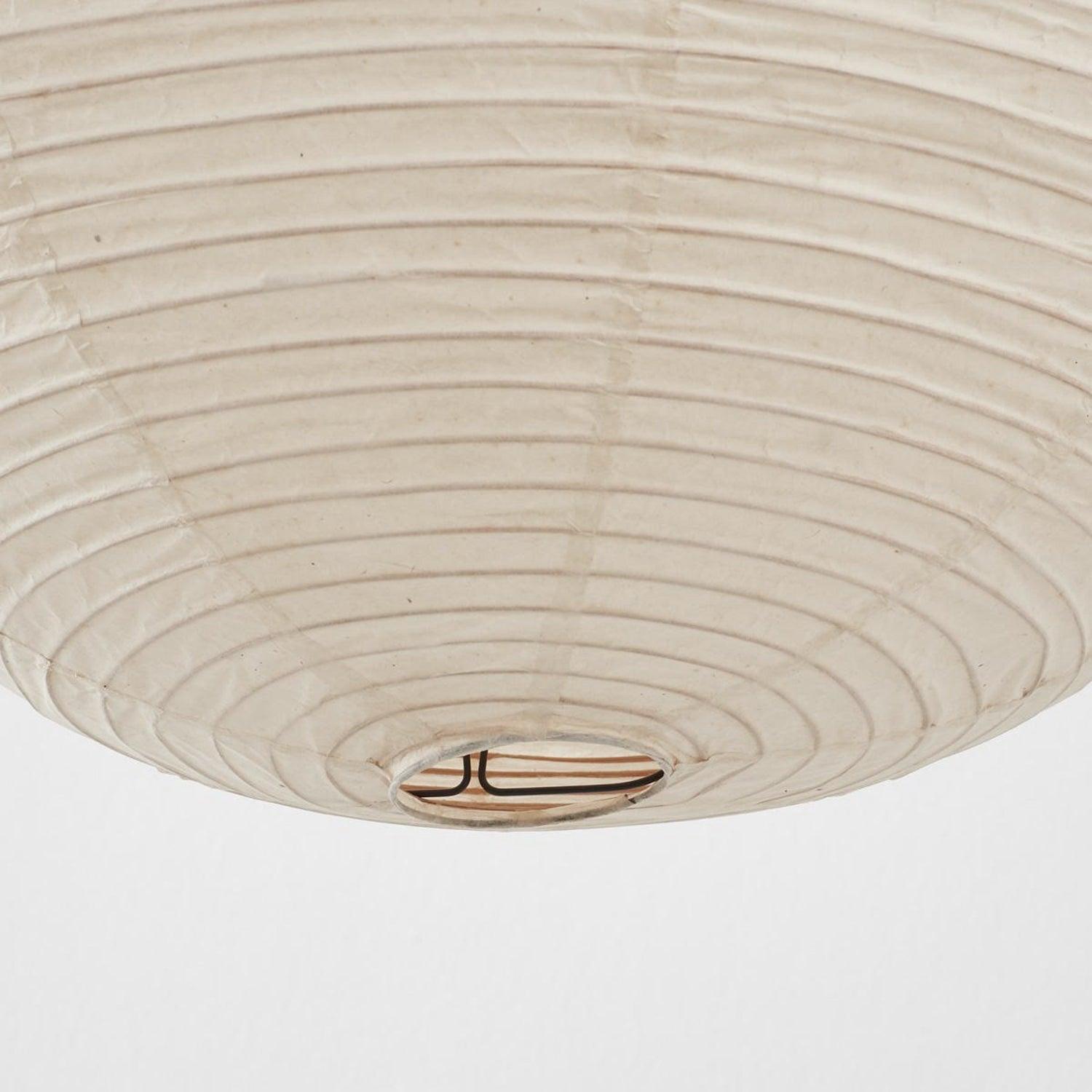 Underside close-up of White ribbed paper shade with circular opening, metal ring and support struts