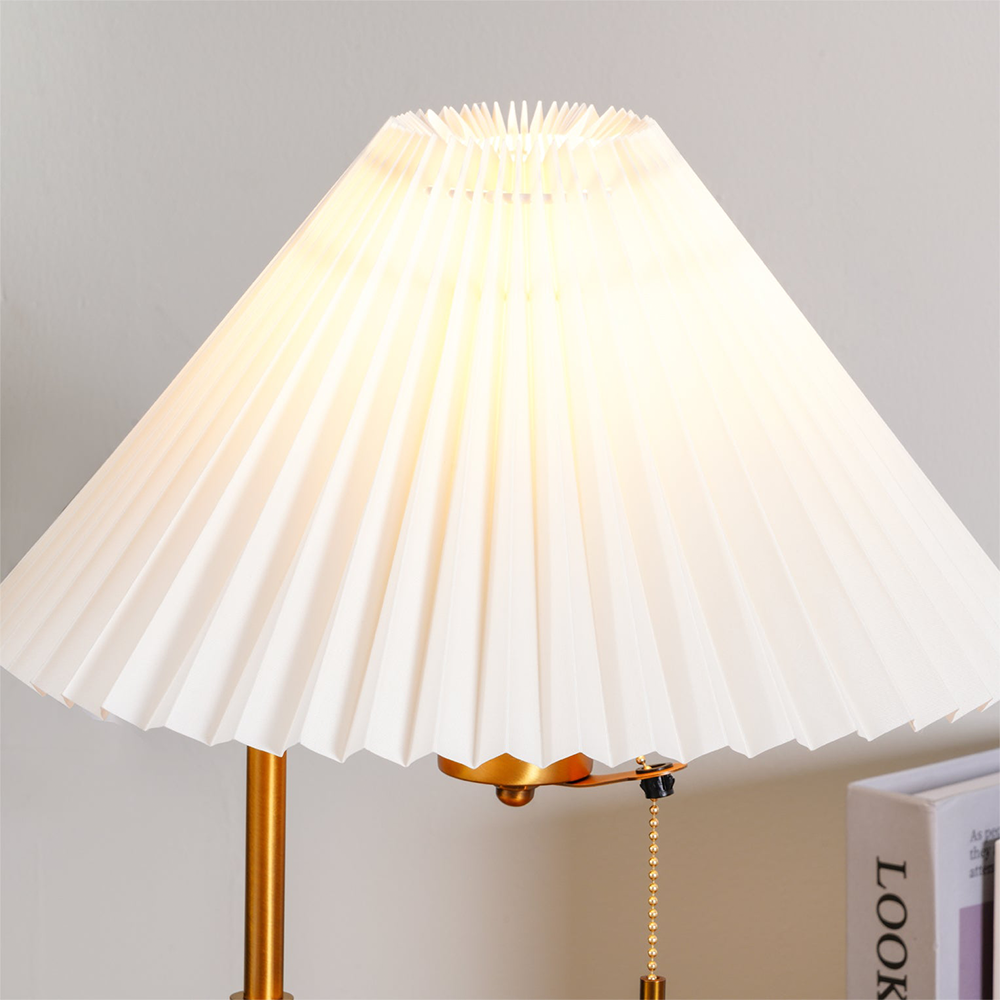 Illuminated pleated shade close-up with a top opening and gold-tone pull chain at right