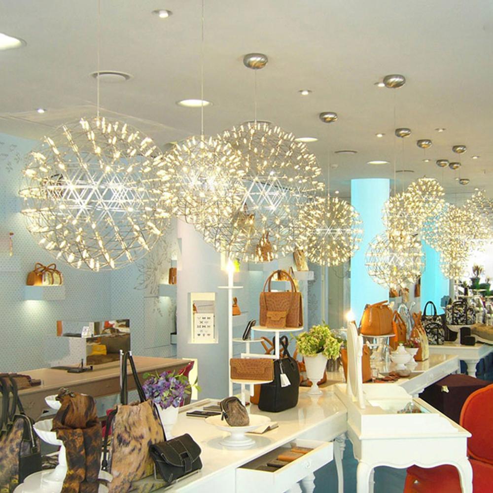 Lattice globe pendants above pale display counters in a handbag shop with blue columns