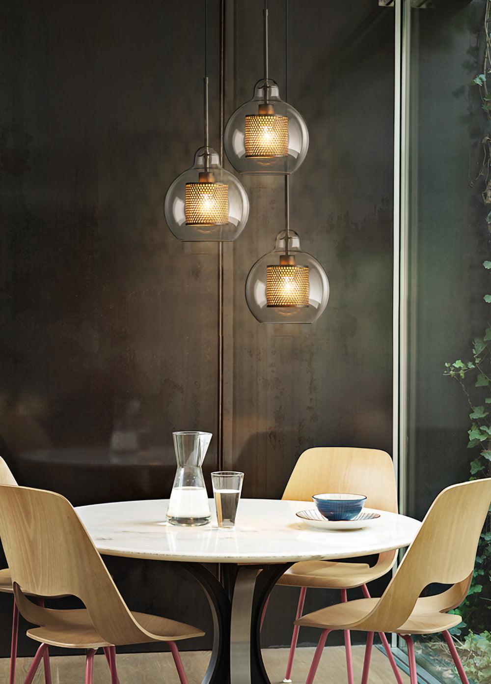Three rounded glass pendants above a round table