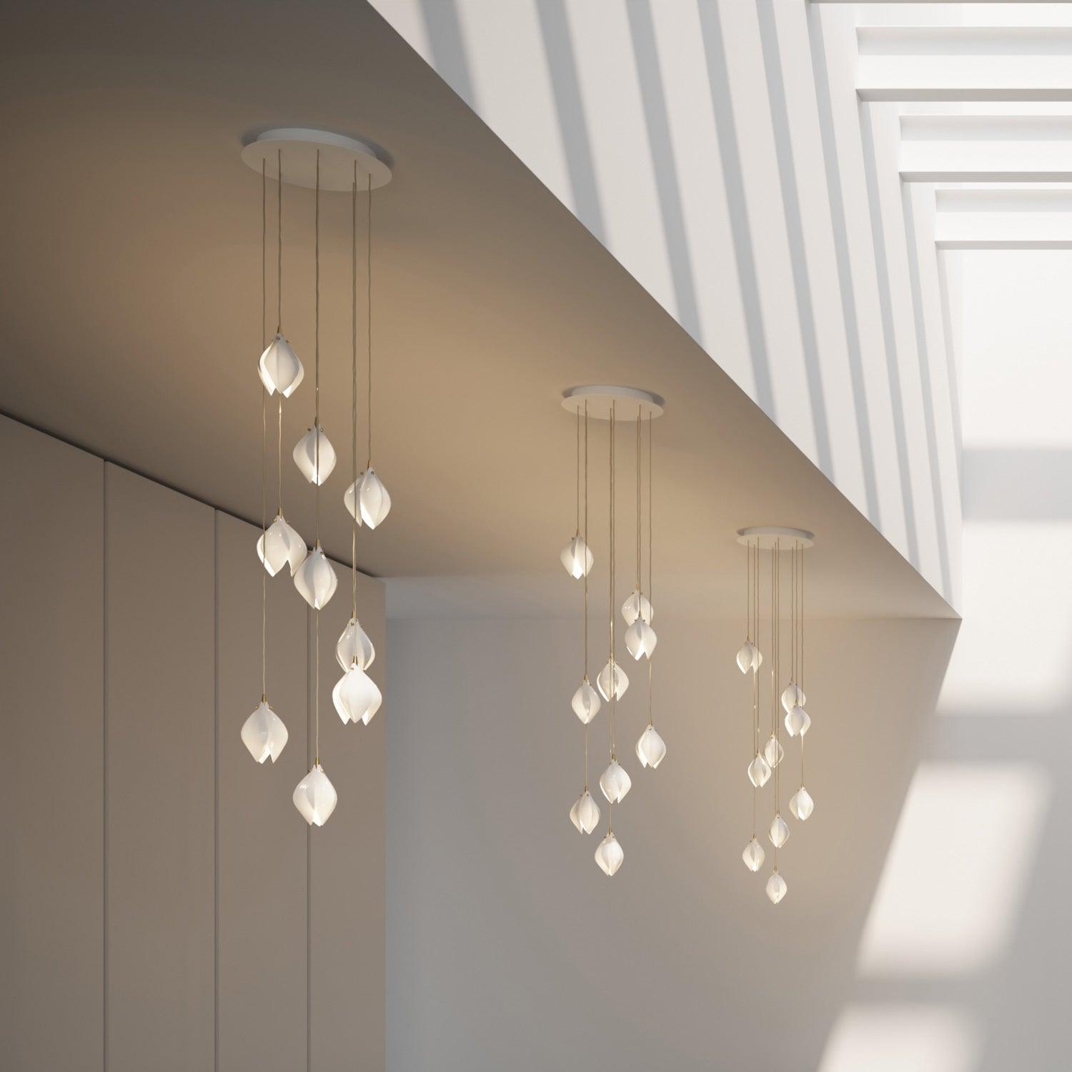 Three separate white ceiling canopies with petal clusters below a roof opening