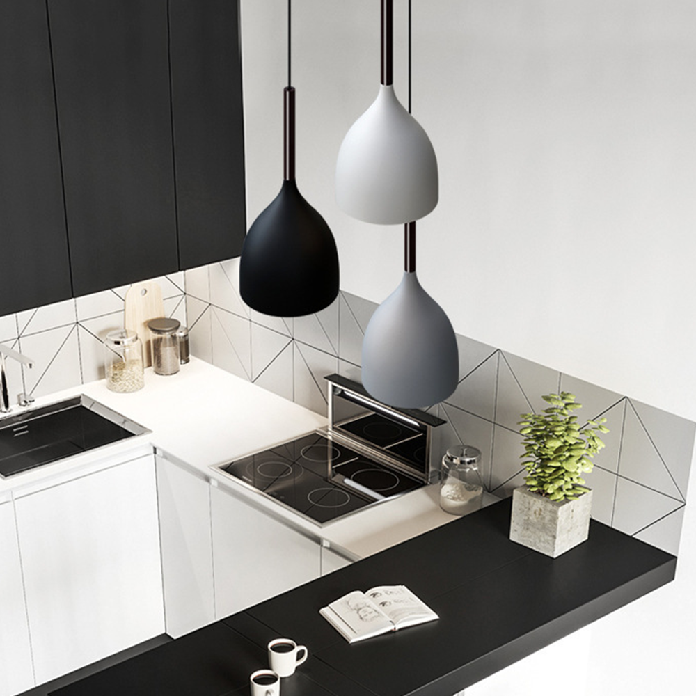 Black, white and grey bell-shaped shades seen above a kitchen counter and cooktop